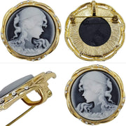 Broche-colgante camafeo redondo en metal dorado. Figura mujer color crema con fondo gris. Rodeado de brillantes de strass. Diámetro de 4,5 cm. Se puede usar como colgante.