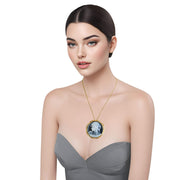 Broche colgante camafeo redondo en metal dorado. Figura mujer color crema con fondo gris. Rodeado de brillantes de strass. Diámetro de 4,5 cm. Se puede usar como colgante.
