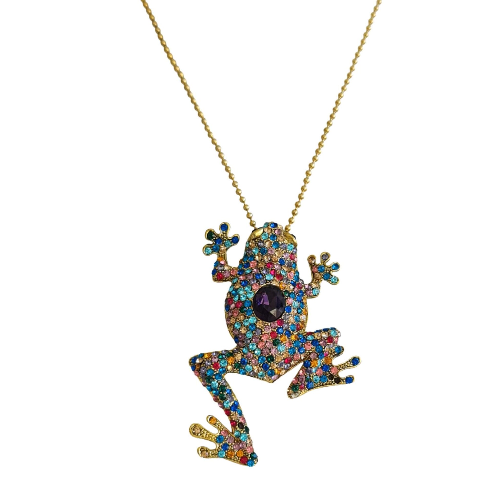 Broche rana colgante de metal dorado y brillantes de strass multicolor. Trasera en color oro viejo con alfiler y seguro.
Puede usarse también como colgante con una cadena ya que lleva una argolla en la parte superior. Mide 8 cm de largo x 5 cm de ancho.